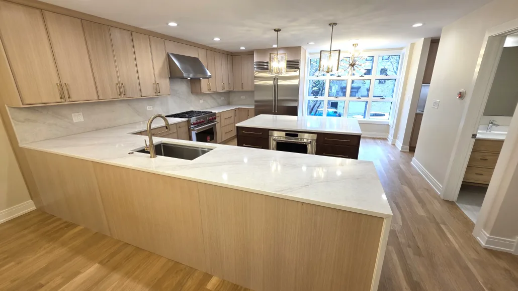 Maya Construction kitchen remodel with wood cabinetry, a peninsula, and stone countertops.